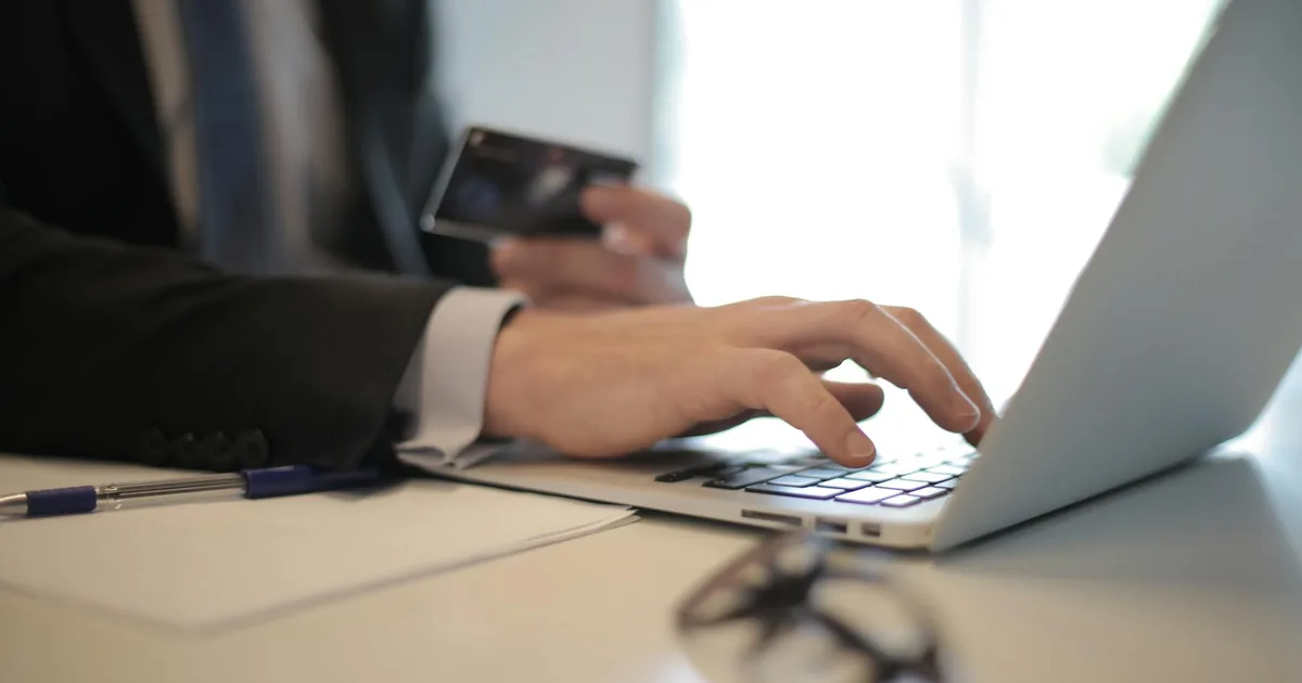 Business professional in suit reviewing data on laptop — Shopify to QuickBooks Online integration and payout automation 2024