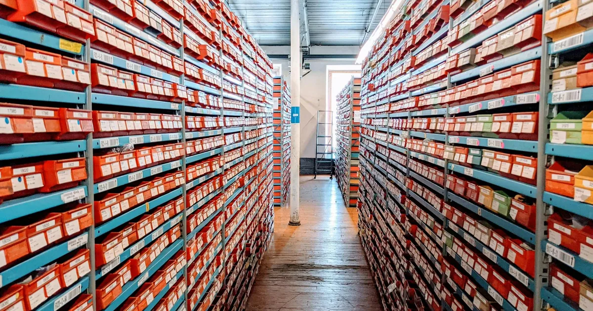 Organized warehouse shelving filled with rows of red shoe boxes — Shopify SKU item matching for QuickBooks Online automation